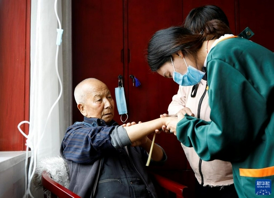 9月3日，在甘肃甘南夏河县拉卜楞综合社会福利中心，护理人员给老人输液。新华社记者 冯亚松 摄