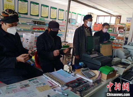 3月伊始,在甘肃酒泉市瓜州县锁阳城镇农丰农资专业合作社里,不同型号的面粉和麸皮摆放得整整齐齐,等待农户前来兑换。图为农户等待办理“面粉存折”。 朱丹丹 摄