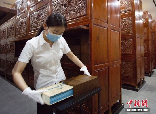 8月17日,甘肃省兰州市天庆博物馆的工作人员在整理该馆收藏的文渊阁版《四库全书》影印本。中新社记者 高展 摄