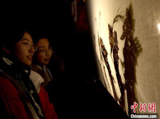 在以“非遗”为主的春节文化活动中,皮影戏吸引了中学生观看。(资料图) 王纲 摄