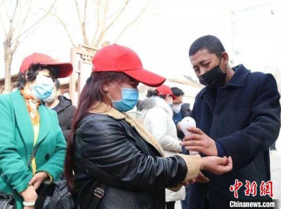 图为所有务工人员上车前接受了体温测量。 甘肃省交通运输厅供图