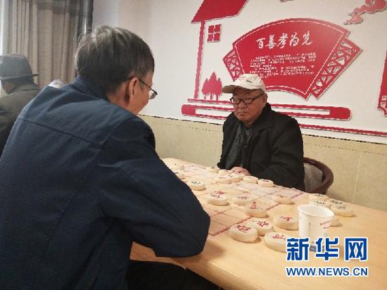 图为康乐寿医护养老院的两名老人正在下棋消闲。