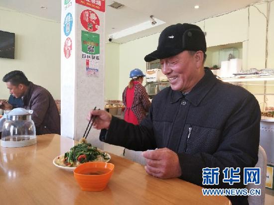 图为领取到免费午餐的张彦祥老人。