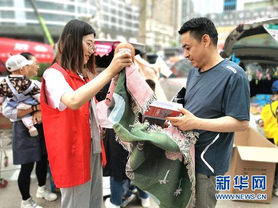 志愿者正在为市民展示爱心义卖物品。新华网发(宋昱静 摄)