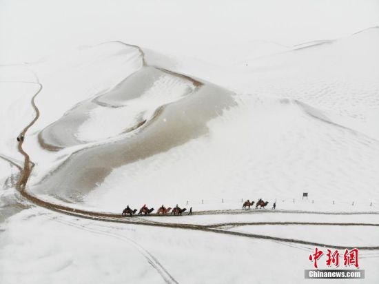 2018年,甘肃酒泉敦煌鸣沙山月牙泉现雪色沙海。(无人机照片) 中新社记者 杨艳敏 摄
