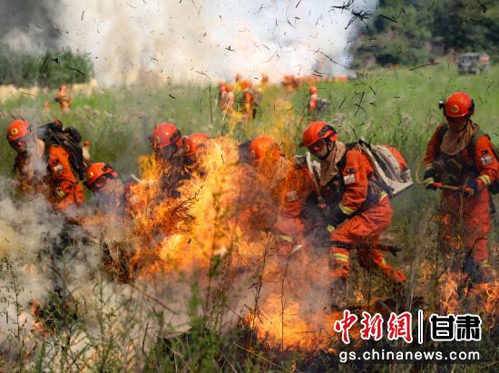 图为指战员在采用一点突破战术扑打火线。