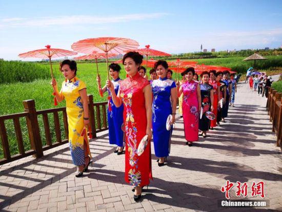 旗袍爱好者手持油纸伞,身着精美的旗袍,一展中国传统之美。吴学珍 摄