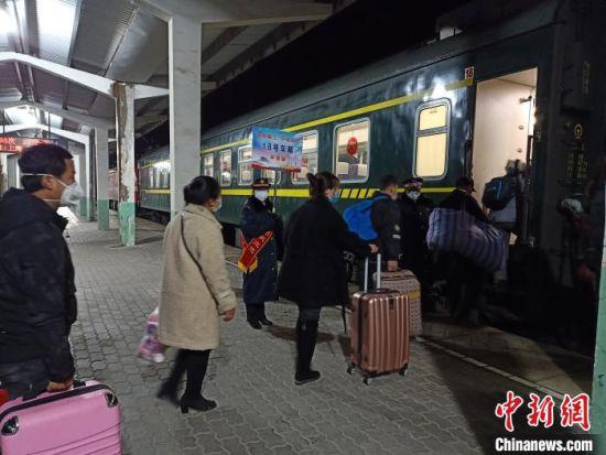 图为务工人员在铁路工作人员引导下乘车。 关杰 摄