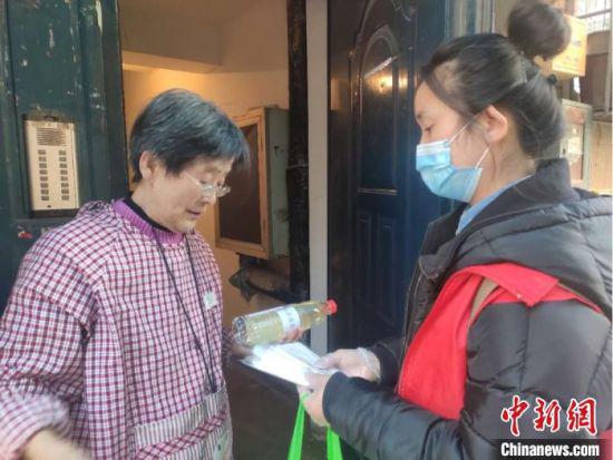 兰州社区网格员高璐娜为居民送去水和口罩。 闫姣 摄