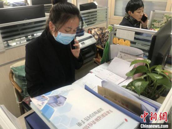 图为兰州城关区宁卧庄社区网格员致电居民,询问身体健康等信息。 闫姣 摄