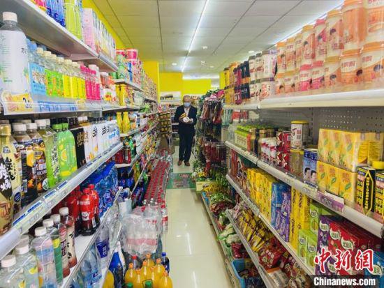 图为郭平安去超市购买食物。 高康迪 摄
