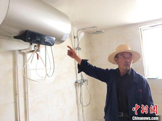 图为刘向信展示自家安装的热水器。
