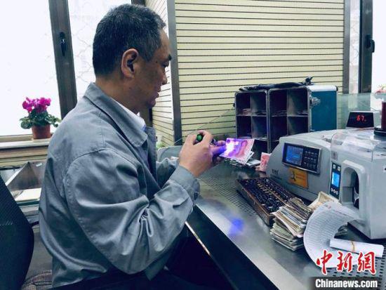 2019年,工商银行兰州分行现金运营中心清点部货币“打假员”蔡学军工作瞬间。(资料图) 艾庆龙 摄