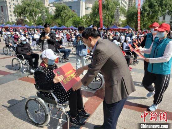 5月16日,兰州市第三十一次“全国助残日”系列活动举办。图为给残障人士捐赠轮椅。 闫姣 摄
