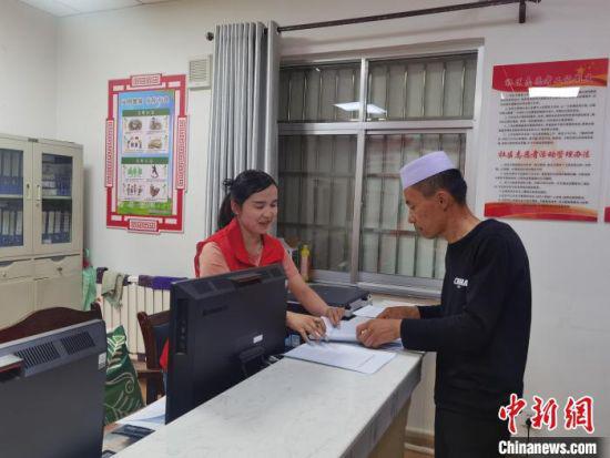 图为武威凉州区东关街寺巷子社区工作人员为少数民族居民办理业务。 崔琳 摄
