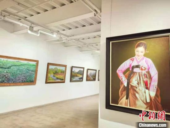 图为7月27日,“惟美无界—当代朝鲜油画名家精品展”正在兰州展出,吸引民众驻足欣赏。 史静静 摄
