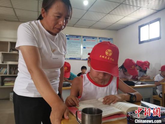 图为王玉红指导留守儿童做作业。 受访者供图