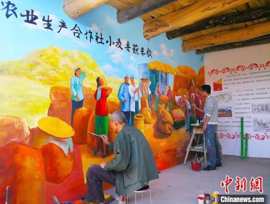图为甘肃境内手艺人描绘“红色记忆墙”。(资料图) 高展 摄