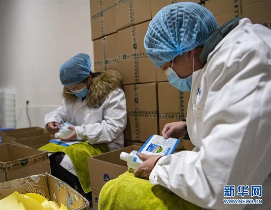 在西藏拉萨一家企业,复工后的生产车间里,工人在给灌装好的消毒液贴标签(2月17日摄)。 新华社记者 孙非 摄