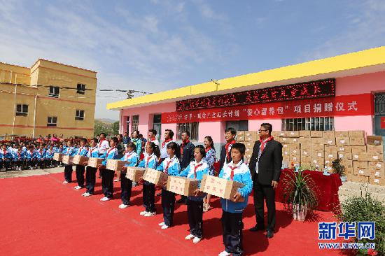 爱心人士为新营小学的贫困儿童捐赠价值10万元的婴幼儿配方奶粉。 信江 摄