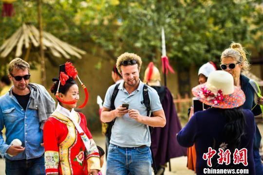 10月5日,中外游客在敦煌古城观光游览。 王斌银 摄