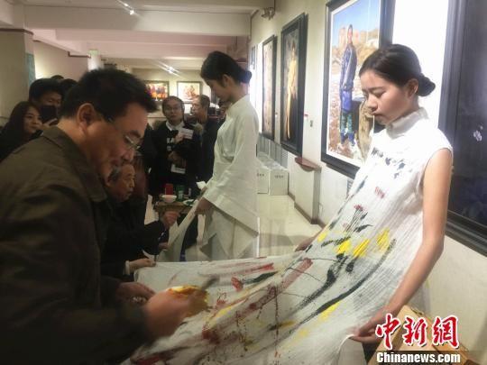 10月18日下午,王秀章携手五名甘肃籍画家在模特服装上手绘,创作了一系列含有中国元素的的画作。 史静静 摄