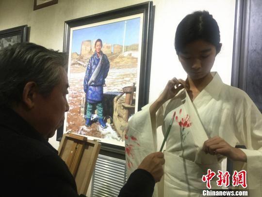 图为10月18日下午,画家现场在模特的服装上创作手绘作品。 史静静 摄
