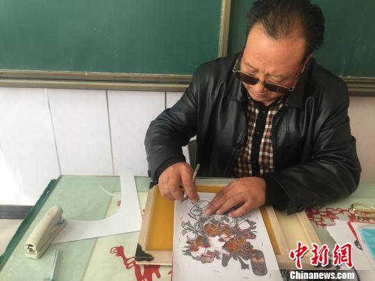 图为卢建坤在蜡盘上刀刻作品。 崔琳 摄