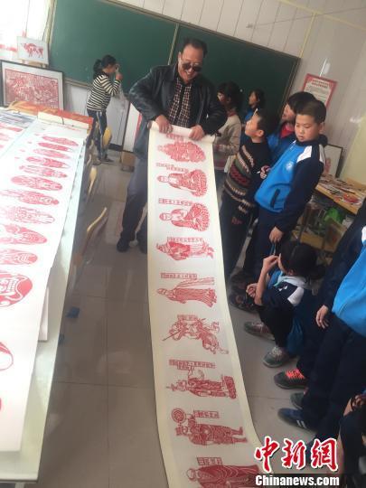 图为学生们围观、学卢建坤的作品。 崔琳 摄