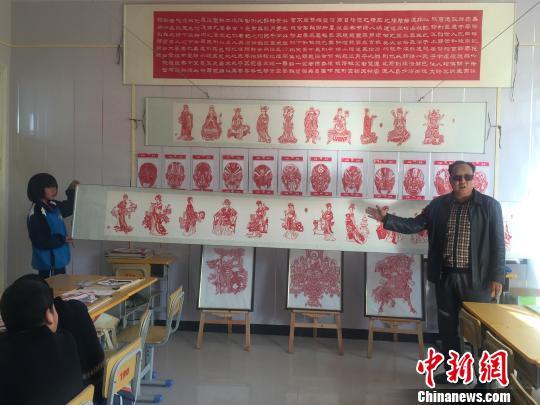 图为卢建坤介绍刀刻作品《金陵十二衩》。 崔琳 摄