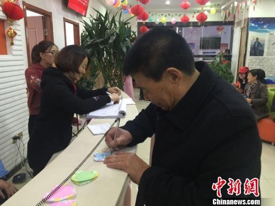 图为老人在便利贴上写下自己的心愿。 杨娜 摄