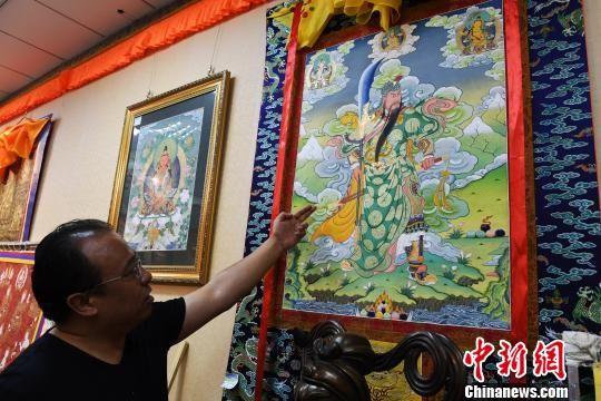 图为藏族唐卡画师夏吾多杰介绍唐卡作品。 杨艳敏 摄
