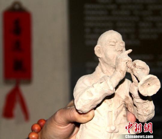 图为泥塑作品《喜迎亲》中唢呐手。 郭惠民 摄