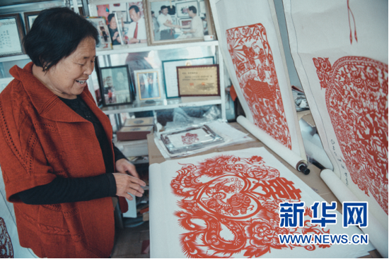 雪秀梅展示自己的剪纸作品。