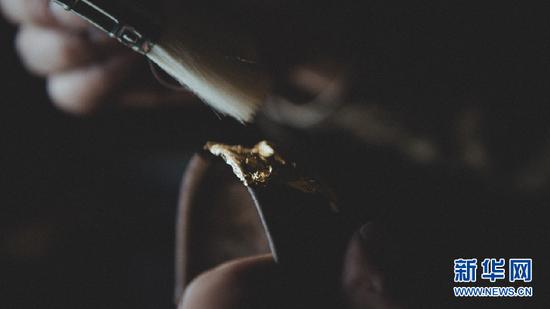 从指间溜走的时光,被永恒凝固在漆器上(图为在漆艺创作中运用金箔纸)。