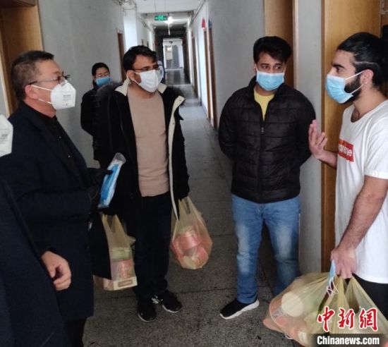 他们为留校学生发放口罩和宅时所需食品。受访者供图