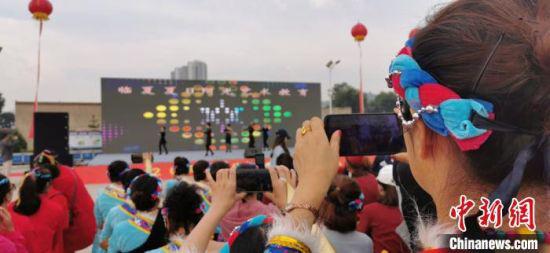 9月初,甘肃临夏州临夏市举办广场舞大赛展演。图为舞蹈演员拍摄记录精彩瞬间。
