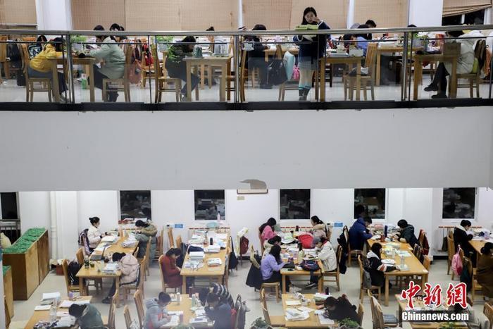 资料图:贵州民族大学逸夫图书馆内,考研学生正在看书复习。 中新社记者 瞿宏伦 摄