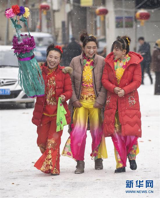 2月17日,在甘肃省陇南市武都区鱼龙镇卯家庄村,高山戏演员在雪中走向戏台。 新华社记者 才扬 摄