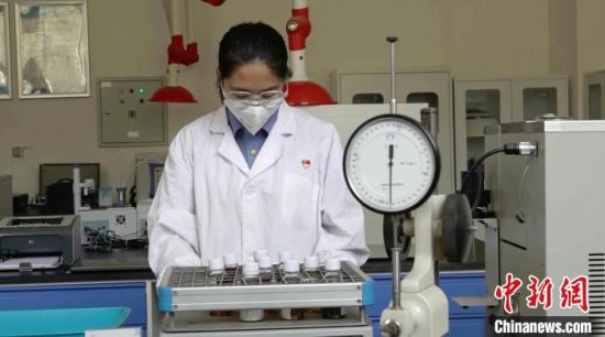 7月中旬,地勤机械师原佳瑞手持润滑油样品,操作机器进行油样化验。 艾庆龙 摄