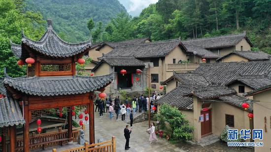 游客在陇南市康县岸门口镇朱家沟村参观游览(无人机照片,5月21日摄)。新华社记者 陈斌 摄