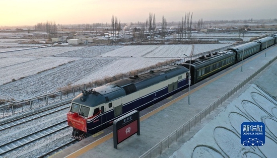 12月26日，酒额铁路酒泉至东风段首发列车准备驶离肃州车站（无人机照片）。新华社 陈斌 摄