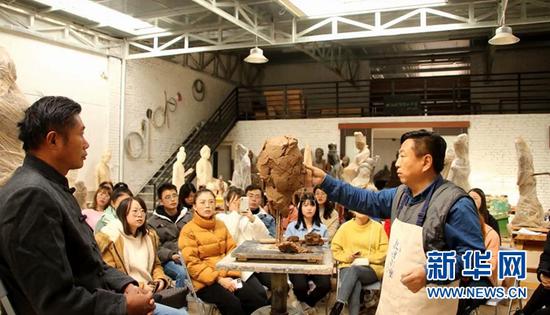 敦煌文化学院学员在敦煌非物质文化遗产传承基地莫高里工匠村体验非遗传承彩塑制作。(敦煌文化学院供图)