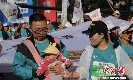 有婴儿还在背带里也与父母一起运动,体验“人生的第一场马拉松”。 史静静 摄