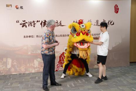 向南醒狮队队长郑国森向外国友人Paul传授舞狮技巧