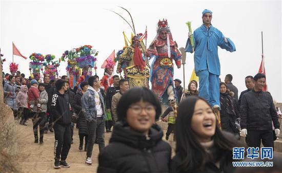 2月19日,在甘肃省陇南市武都区马街镇寺背村,社火队演员参加巡游表演。 新华社记者 才扬 摄