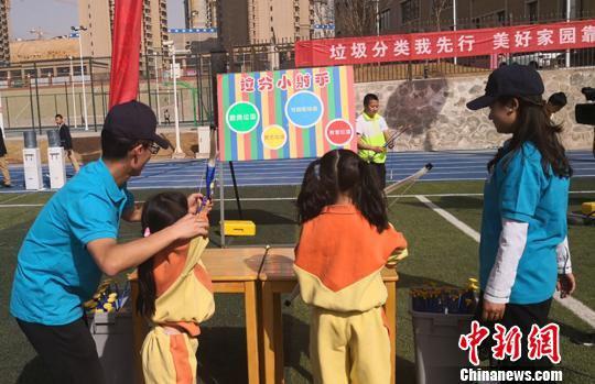 图为同学们体验“垃圾分类我来射”小游戏。 崔琳 摄