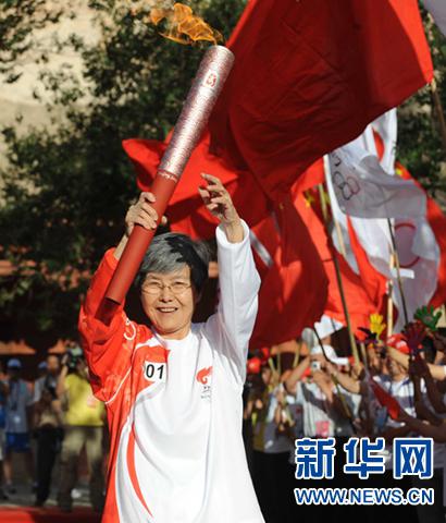 2008年7月5日,奥运圣火在甘肃敦煌传递,第一棒火炬手、敦煌研究院院长樊锦诗手持火炬进行传递。新华社记者 韩传号 摄