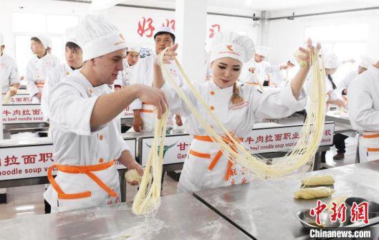 2018年4月,来自哈萨克斯坦、澳大利亚等国学员在甘肃兴陇兰州牛肉拉面职业培训学校学习牛肉面制作工艺,经过几天的学习,学员们拉出的面可以“细如发丝”。(资料图)