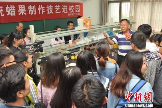 周晶正在给大学生们讲解蜡果制作技巧。(资料图) 钟欣 摄